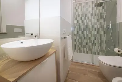 a bathroom with a white sink and a shower at Anna's Central Apartment in Palermo