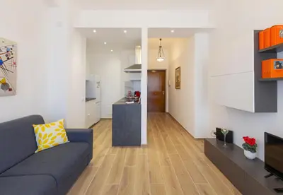 a living room with a couch and a kitchen at Anna's Central Apartment in Palermo