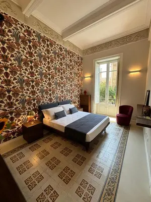 a bedroom with a bed in a room with wallpaper at Galioto Sperlinga Luxury Boutique Apartments in Palermo