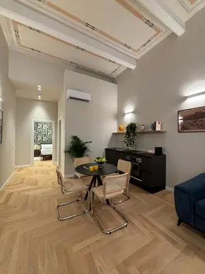 a living room with a table and chairs and a couch at Galioto Sperlinga Luxury Boutique Apartments in Palermo