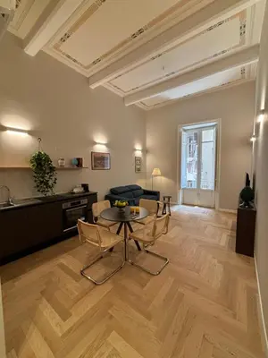 a living room with a table and chairs and a kitchen at Galioto Sperlinga Luxury Boutique Apartments in Palermo