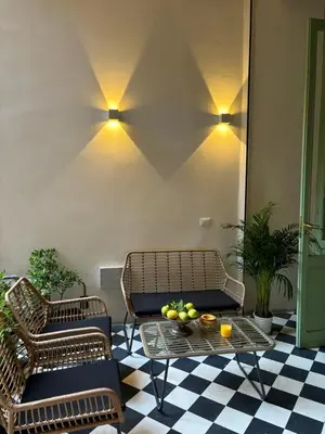 two chairs and a table with fruit on a checkered floor at Galioto Sperlinga Luxury Boutique Apartments in Palermo