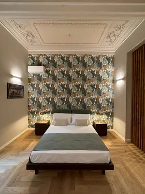 a bedroom with a large bed and a wall at Galioto Sperlinga Luxury Boutique Apartments in Palermo