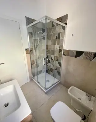 a bathroom with a shower and a toilet and a sink at Casa Delle Femmine in Isola delle Femmine