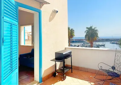 a door to a balcony with a view of the ocean at Solemar Sicilia - Casa Eos in Porticello