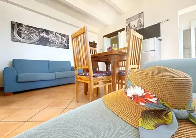 a living room with a blue couch and a table at Solemar Sicilia - Casa Eos in Porticello