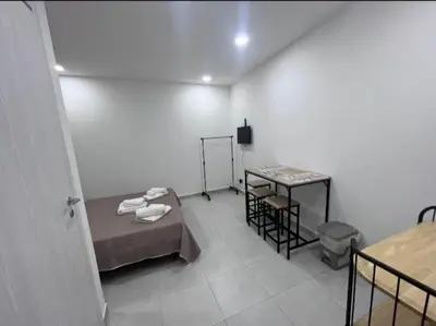 a room with two beds and a table in it at Le stanze di Rosalia in Palermo