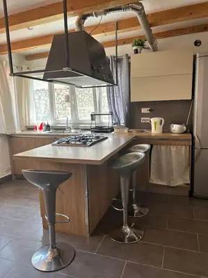 a kitchen with a island with bar stools in it at Finc house in Palermo