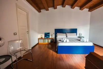 a bedroom with a blue bed and a wooden floor at iFlat Sicilia Le terrazze blu in Palermo