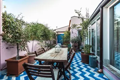 an outdoor patio with a wooden table and chairs at iFlat Sicilia Le terrazze blu in Palermo