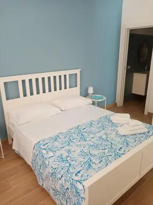 a bedroom with a large bed with a blue wall at Mediterranea casa vacanza in Capaci
