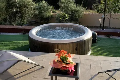 a large circular soaking tub with a vase of flowers on a table at Villa Serena - vasca idromassaggio in Borgetto