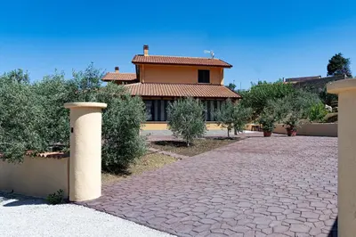 a house with a brick driveway in front of a building at Villa Serena - vasca idromassaggio in Borgetto