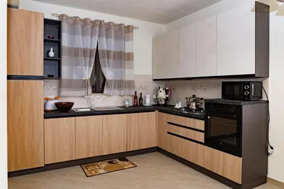 a kitchen with wooden cabinets and a black microwave at Villa Serena - vasca idromassaggio in Borgetto