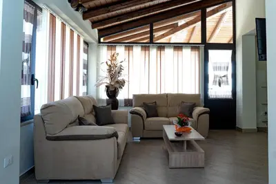 a living room with two couches and a table at Villa Serena - vasca idromassaggio in Borgetto