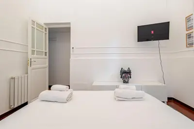 a bedroom with a white bed with two white towels at Liberty Boutique Apartment in Palermo