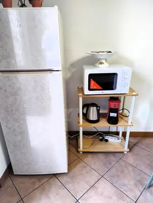 a kitchen with a microwave and a refrigerator at Rimpetto alle Clarisse in Palermo