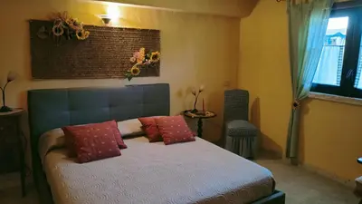 a bedroom with a bed with red pillows and a window at Villa Sterlizia in Castellammare del Golfo