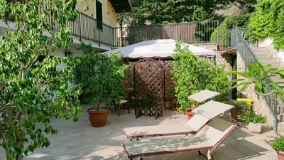 a patio with a table and chairs and trees at Villa Sterlizia in Castellammare del Golfo