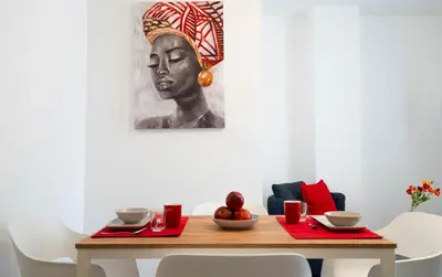 a dining room table with a painting of a woman at Le Stanze del Duomo in Partinico