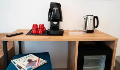 a table with a coffee machine and a magazine at Le Stanze del Duomo in Partinico