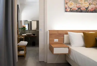 a bedroom with a bed and a bathroom with a sink at Le Stanze del Duomo in Partinico