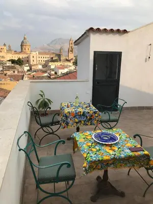 a patio with two tables and chairs on a roof at Casa Rosa in Palermo