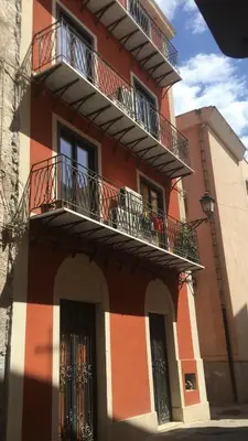 an orange and white building with two balconies at Casa Rosa in Palermo
