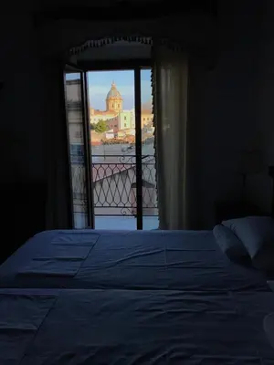a bedroom with a bed and a view of a building at Casa Rosa in Palermo