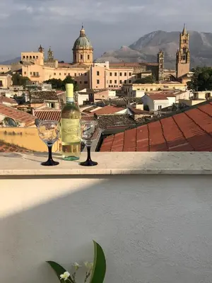 a bottle of wine and two wine glasses on a ledge at Casa Rosa in Palermo