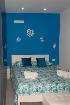 a blue bedroom with a bed with a blue wall at Lido Azzurro Sea Apartments in Carini