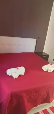 two towels on a bed with a red blanket at Lido Azzurro Sea Apartments in Carini