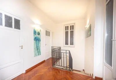 a hallway with a staircase and paintings on the walls at Aria di sale in Palermo