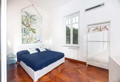 a white bedroom with a bed and a window at Aria di sale in Palermo