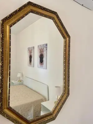 a mirror on a wall with a bed in a room at Loriano Apartment in Capaci