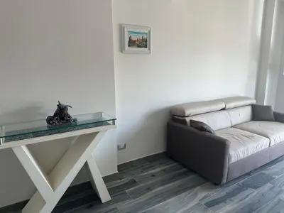 a living room with a couch and a television at Casa vacanze Rosalinda House di fronte al mare di Palermo in Palermo