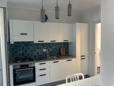 a kitchen with white cabinets and a sink at Casa vacanze Rosalinda House di fronte al mare di Palermo in Palermo