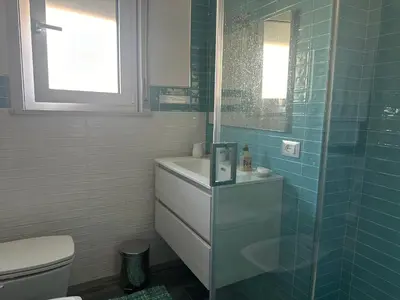 a bathroom with a toilet and a glass shower at Casa vacanze Rosalinda House di fronte al mare di Palermo in Palermo