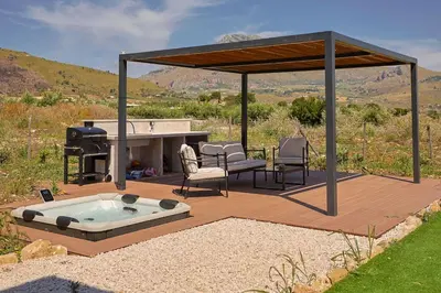 a deck with a hot tub and a grill at Dimora Masi di GN Real Escapes in Castellammare del Golfo