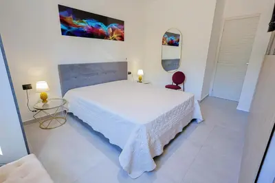 a bedroom with a white bed and two lamps at Dimora Masi di GN Real Escapes in Castellammare del Golfo