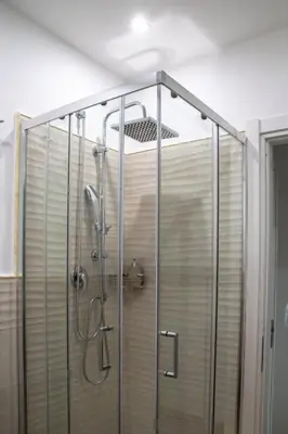 a shower with a glass enclosure in a bathroom at Politeama Crystal Rooms in Palermo