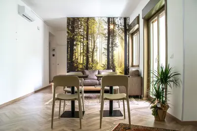 a dining room with a table and chairs and trees mural at Politeama Crystal Rooms in Palermo