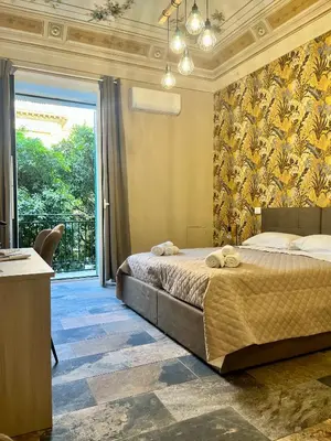 a bedroom with a bed and a large window at B&B Dimora Emily in Palermo