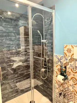 a shower with a glass door in a bathroom at B&B Dimora Emily in Palermo