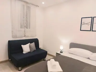 a bedroom with a bed and a blue chair at Murriali Apartment in Monreale