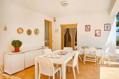a kitchen and dining room with a table and chairs at Villa Azzurra a pochi passi dal mare in Castellammare del Golfo