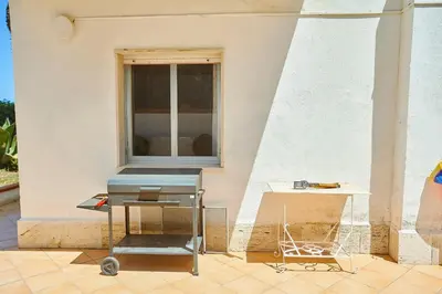 a grill sitting on a patio next to a window at Villa Azzurra a pochi passi dal mare in Castellammare del Golfo