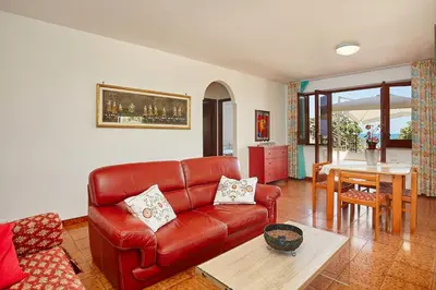 a living room with a red leather couch and a table at Villa Azzurra a pochi passi dal mare in Castellammare del Golfo