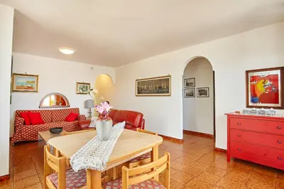 a living room with a table and a red dresser at Villa Azzurra a pochi passi dal mare in Castellammare del Golfo