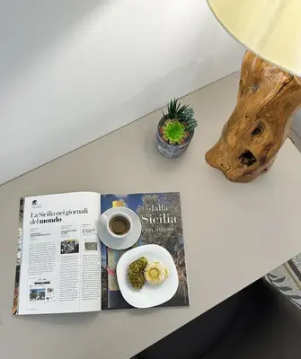 a magazine and a plate of food on a table at Terra d'amuri Rooms in Terrasini